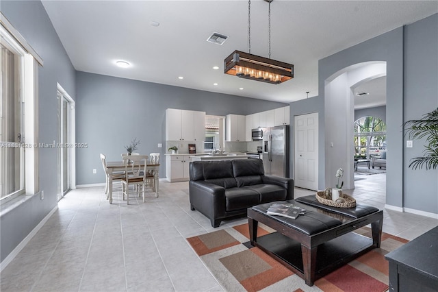 1122 NW 143rd Ave, Pembroke Pines, FL 33028 - living room featuring arched walkways, light tile patterned floors, and recessed lighting