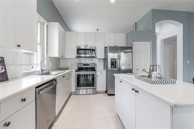 1122 NW 143rd Ave, Pembroke Pines, FL 33028 - kitchen with appliances with stainless steel finishes, decorative backsplash, light countertops, a kitchen island, and white cabinetry