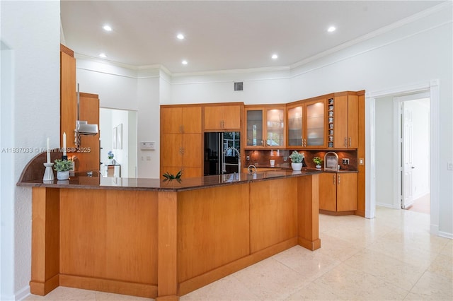 1907 NW 137th Ter, Pembroke Pines, FL 33028 - kitchen with black fridge, brown cabinetry, glass insert cabinets, ornamental molding, and a peninsula