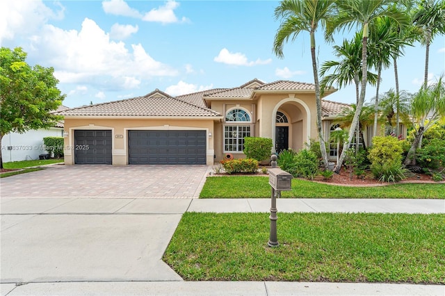 1907 NW 137th Ter, Pembroke Pines, FL 33028 - mediterranean / spanish-style house with stucco siding, a front yard, driveway, a tiled roof, and an attached garage