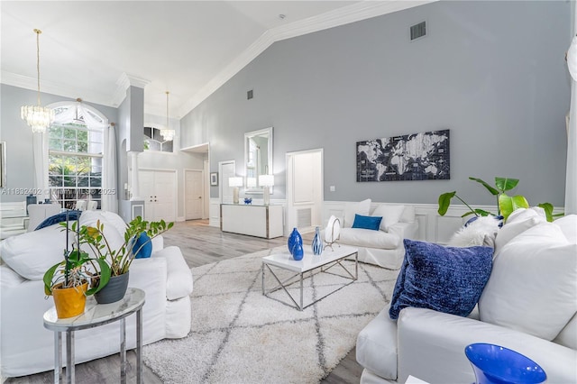 13850 NW 23rd St, Pembroke Pines, FL 33028 - living area with a chandelier, ornamental molding, wood finished floors, high vaulted ceiling, and wainscoting