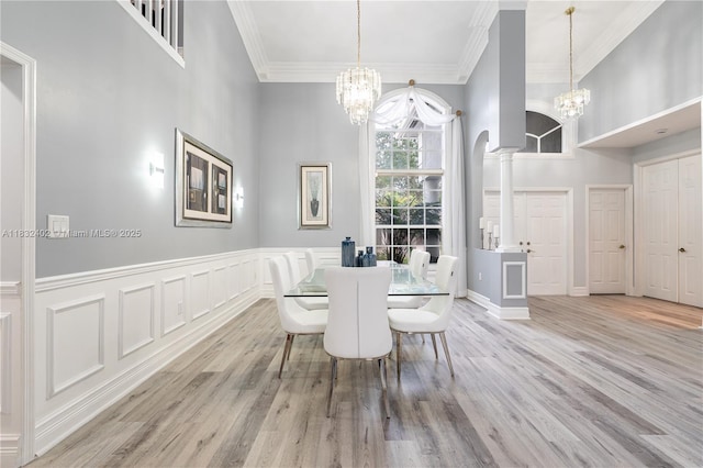 13850 NW 23rd St, Pembroke Pines, FL 33028 - dining area featuring a chandelier, crown molding, wood finished floors, ornate columns, and a towering ceiling