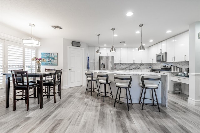 13850 NW 23rd St, Pembroke Pines, FL 33028 - kitchen featuring appliances with stainless steel finishes, tasteful backsplash, light wood-style floors, and recessed lighting