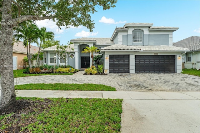 13850 NW 23rd St, Pembroke Pines, FL 33028 - mediterranean / spanish house featuring a tile roof, decorative driveway, stucco siding, and an attached garage