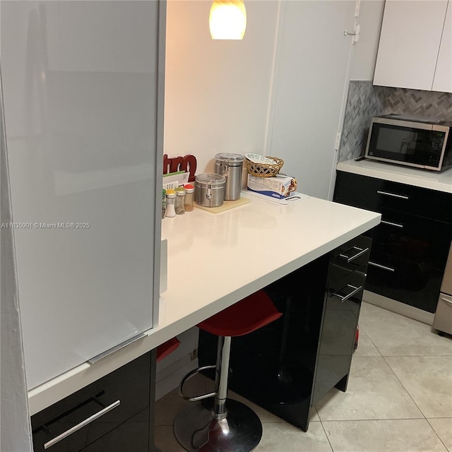 400 Kings Point Dr Unit 623, Sunny Isles Beach, FL 33160 - kitchen with stainless steel microwave, dark cabinetry, light countertops, and modern cabinets