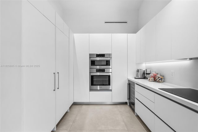 9033 Emerson Ave, Surfside, FL 33154 - kitchen with stainless steel double oven, light countertops, white cabinetry, and modern cabinets