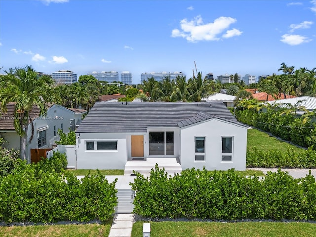 9033 Emerson Ave, Surfside, FL 33154 - view of front of home with stucco siding, a tiled roof, and a city view