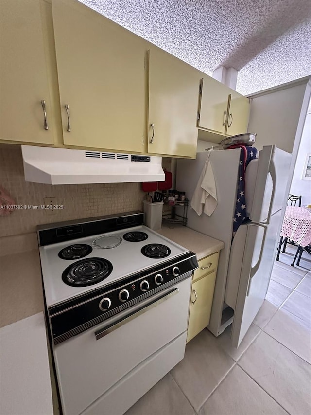 920 SW 11th Ave Unit 12A, Hallandale Beach, FL 33009 - kitchen with white appliances, under cabinet range hood, light tile patterned flooring, and light countertops