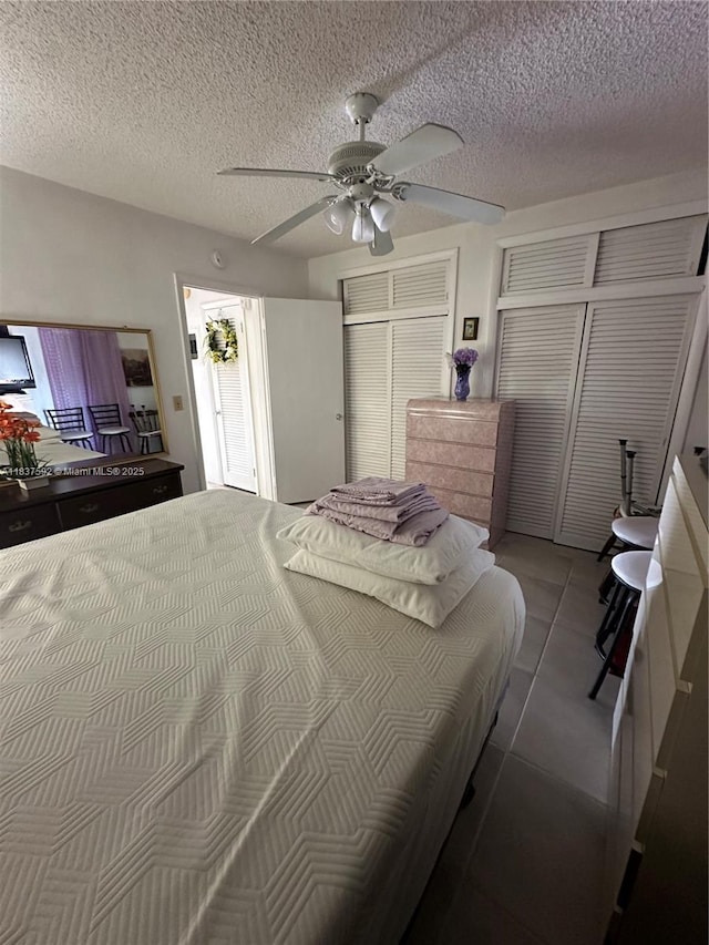 920 SW 11th Ave Unit 12A, Hallandale Beach, FL 33009 - tiled bedroom featuring a ceiling fan, two closets, and a textured ceiling