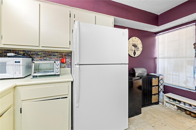 20145 NE 3rd Ct Unit 2, Miami, FL 33179 - kitchen featuring white appliances, light countertops, backsplash, white cabinets, and a textured ceiling