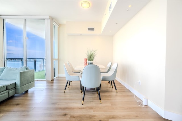244 Biscayne Blvd Unit 4803, Miami, FL 33132 - dining space featuring light wood-type flooring and a wall of windows