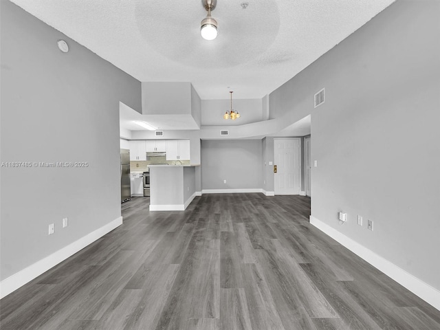 2071 Renaissance Blvd Unit 303, Miramar, FL 33025 - unfurnished living room featuring a textured ceiling, dark wood finished floors, a chandelier, and ceiling fan