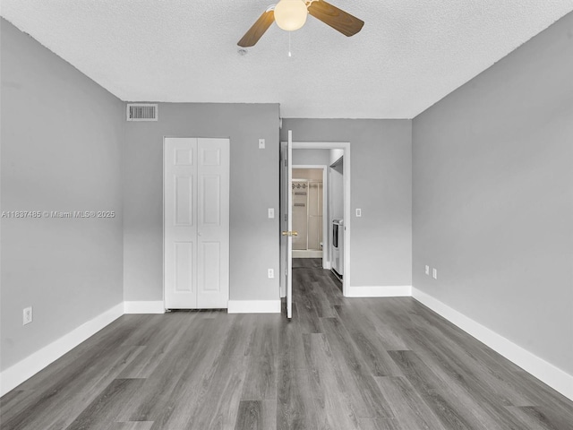 2071 Renaissance Blvd Unit 303, Miramar, FL 33025 - unfurnished bedroom with a textured ceiling, dark wood-type flooring, a ceiling fan, a spacious closet, and washer / dryer
