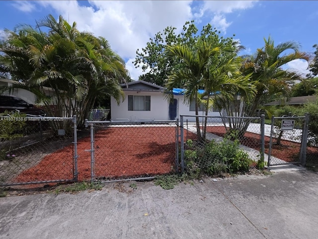 2530 NW 14th Ct, Fort Lauderdale, FL 33311 - view of front of house featuring a gate, a fenced front yard, and stucco siding