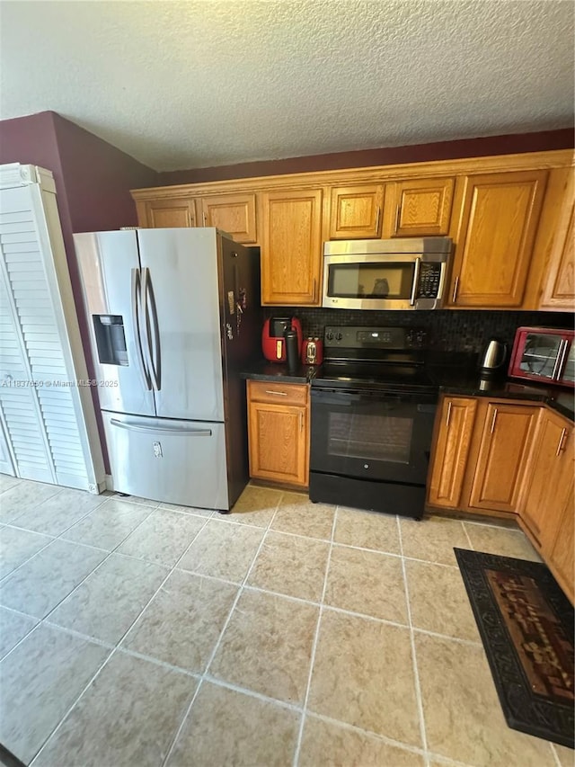 9986 Royal Palm Blvd Unit 9986, Coral Springs, FL 33065 - kitchen featuring appliances with stainless steel finishes, backsplash, dark countertops, brown cabinetry, and a textured ceiling