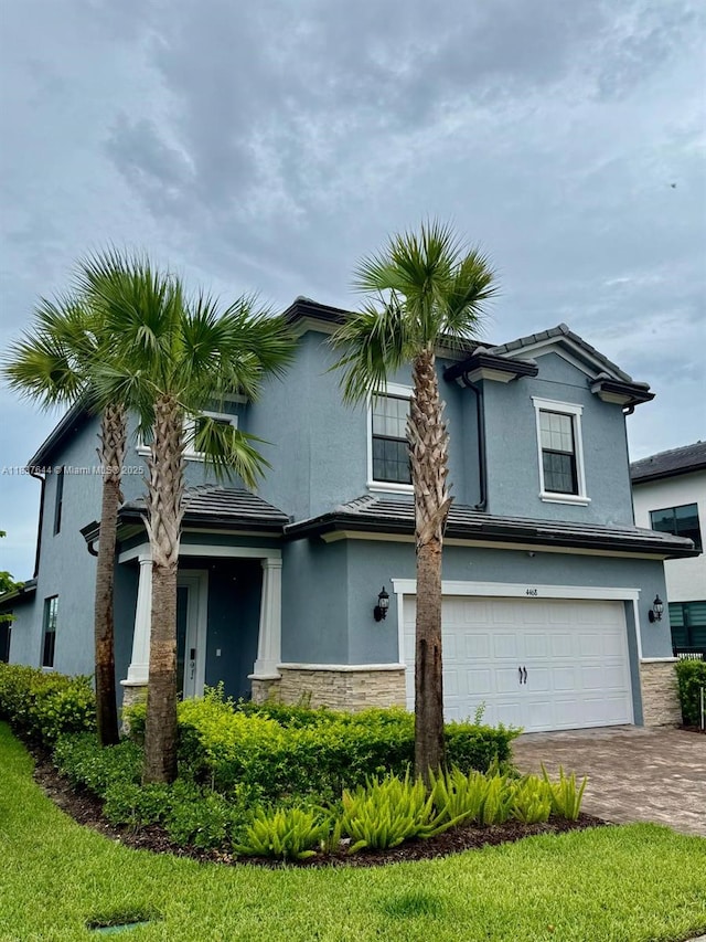 4468 Spruce Ln, Oakland Park, FL 33309 - view of front of house with an attached garage, stucco siding, driveway, and stone siding
