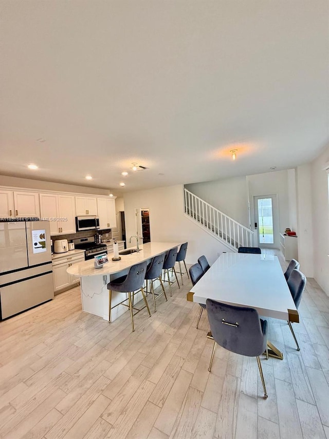 4468 Spruce Ln, Oakland Park, FL 33309 - dining area featuring light wood-style flooring, stairway, and recessed lighting