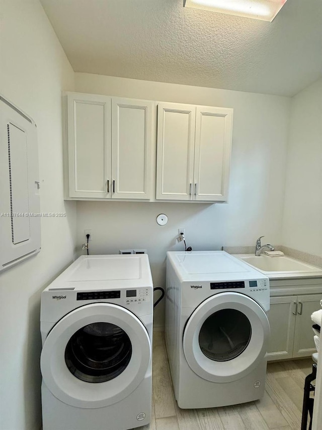 4468 Spruce Ln, Oakland Park, FL 33309 - washroom featuring cabinet space, separate washer and dryer, a textured ceiling, and electric panel