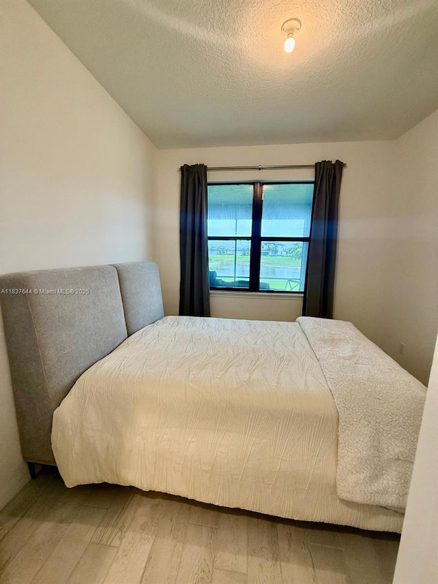 4468 Spruce Ln, Oakland Park, FL 33309 - bedroom featuring wood finished floors, a textured ceiling, and vaulted ceiling