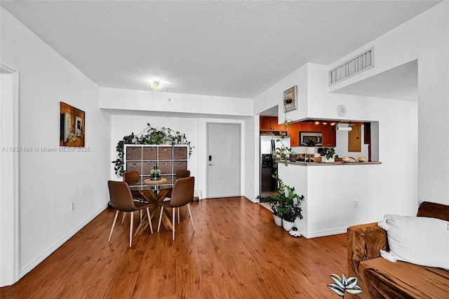 36 NW 6th Ave Unit 701, Miami, FL 33128 - dining space featuring wood finished floors and a textured ceiling
