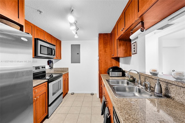36 NW 6th Ave Unit 701, Miami, FL 33128 - kitchen featuring stainless steel appliances, electric panel, light tile patterned floors, brown cabinetry, and a textured ceiling