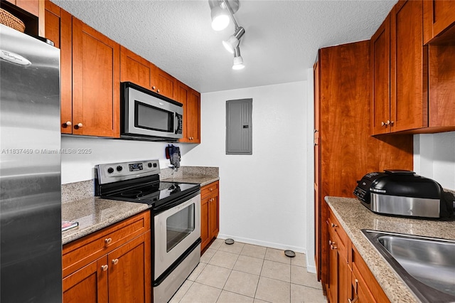 36 NW 6th Ave Unit 701, Miami, FL 33128 - kitchen with appliances with stainless steel finishes, light tile patterned flooring, a textured ceiling, electric panel, and brown cabinetry