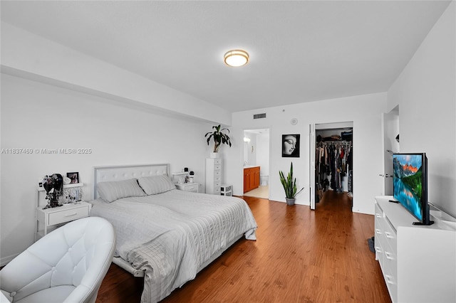 36 NW 6th Ave Unit 701, Miami, FL 33128 - bedroom featuring wood finished floors, a walk in closet, and ensuite bath