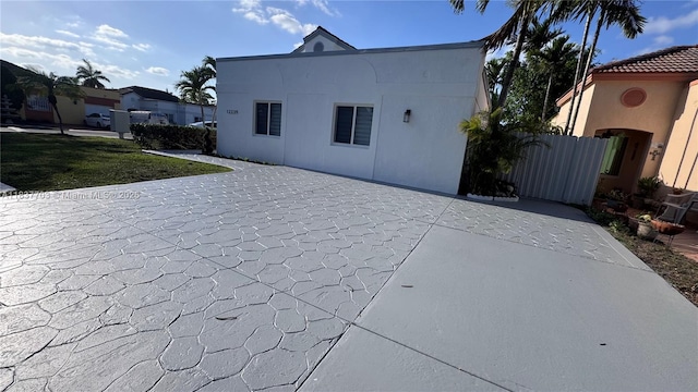 12239 NW 7th St, Miami, FL 33182 - rear view of property featuring stucco siding, a patio, and decorative driveway
