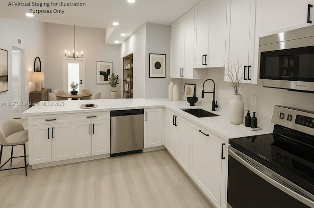 12239 NW 7th St, Miami, FL 33182 - kitchen featuring stainless steel appliances, a peninsula, light wood-type flooring, a chandelier, and light countertops