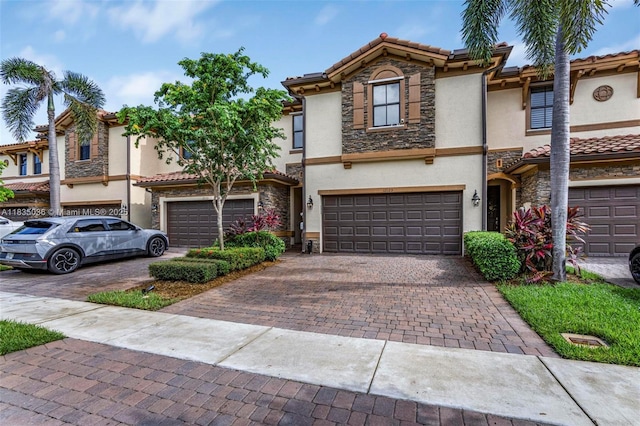 12125 S Vaquero Trails Dr, Davie, FL 33325 - townhome / multi-family property featuring stone siding, stucco siding, decorative driveway, and a tiled roof