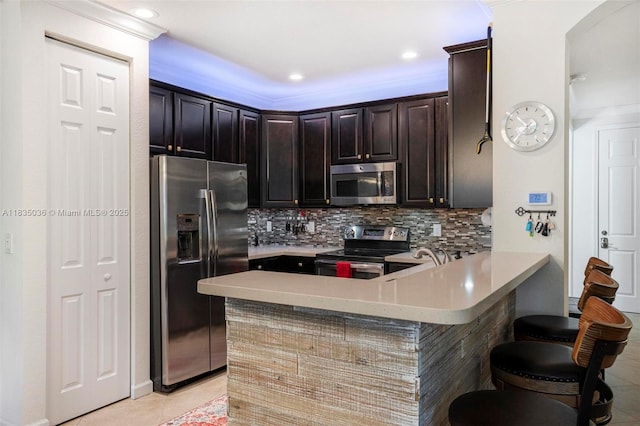 12125 S Vaquero Trails Dr, Davie, FL 33325 - kitchen featuring stainless steel appliances, a peninsula, light countertops, light tile patterned flooring, and recessed lighting