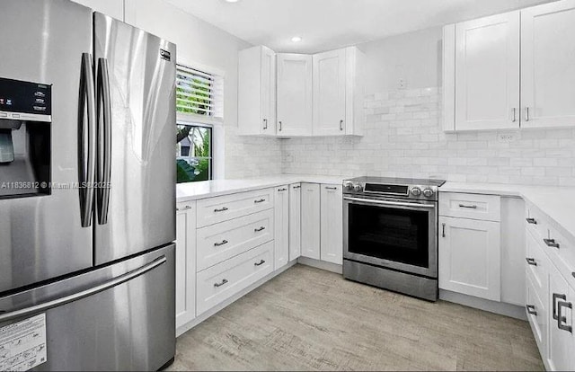 103 Lake Terry Dr, West Palm Beach, FL 33411 - kitchen with stainless steel appliances, light wood finished floors, light countertops, white cabinets, and recessed lighting