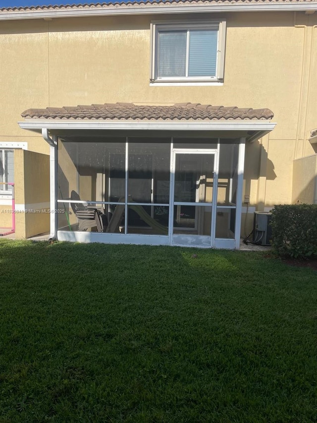 5963 Royal Way, Tamarac, FL 33321 - rear view of house with a lawn, stucco siding, and a sunroom