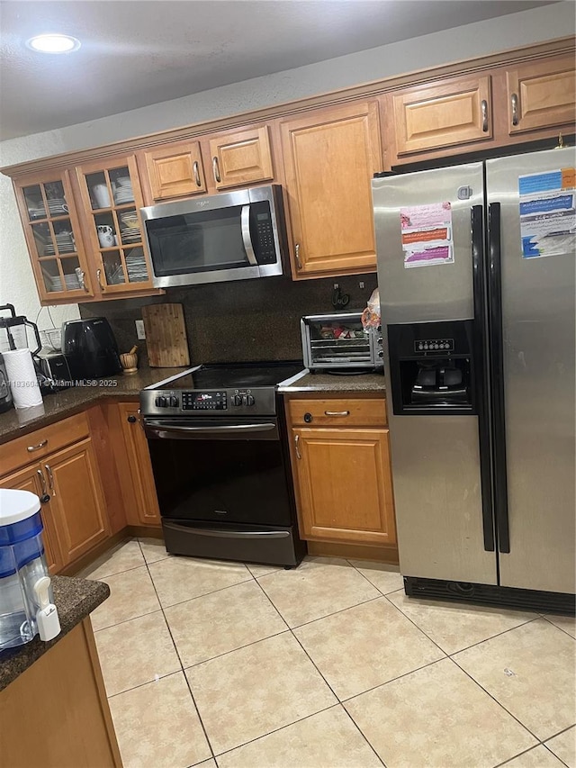 5963 Royal Way, Tamarac, FL 33321 - kitchen featuring appliances with stainless steel finishes, brown cabinetry, glass insert cabinets, light tile patterned flooring, and tasteful backsplash