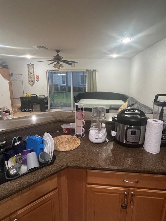 5963 Royal Way, Tamarac, FL 33321 - kitchen with brown cabinetry, ceiling fan, and dark stone countertops