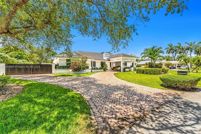 17940 SW 83rd Ave, Palmetto Bay, FL 33157 - view of front facade featuring curved driveway, stucco siding, a fenced front yard, and a chimney