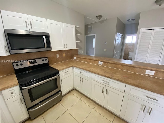 6124 SW 39th St, Miramar, FL 33023 - kitchen with stainless steel appliances, open shelves, white cabinets, and light tile patterned floors