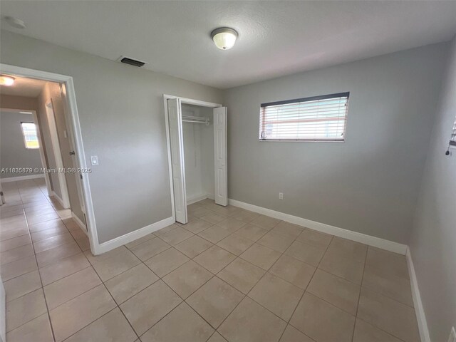 6837 NW 28th St, Sunrise, FL 33313 - unfurnished bedroom with light tile patterned flooring, multiple windows, and a closet