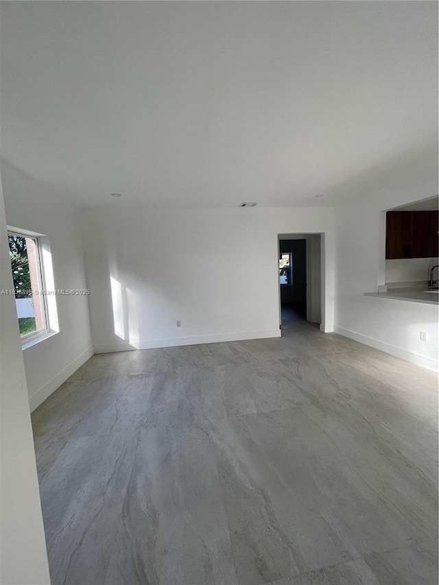 1310 Sharazad Blvd, Opa Locka, FL 33054 - unfurnished living room with finished concrete flooring and baseboards