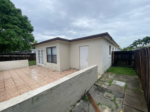7521 Indigo St, Miramar, FL 33023 - view of property exterior with stucco siding, a patio, and a fenced backyard