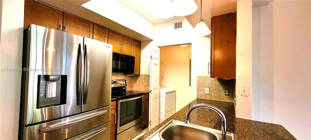 2000 N Bayshore Dr Unit 509, Miami, FL 33137 - kitchen featuring appliances with stainless steel finishes, brown cabinetry, backsplash, washer / dryer, and dark stone countertops