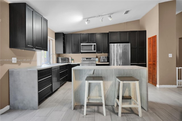 10405 SW 146th Ave, Miami, FL 33186 - kitchen featuring appliances with stainless steel finishes, lofted ceiling, a center island, dark cabinets, and light countertops