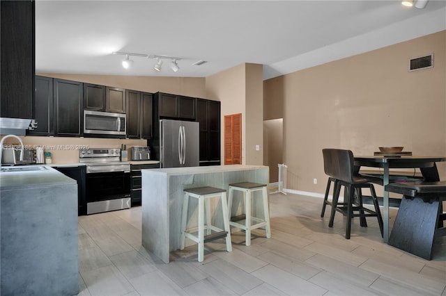 10405 SW 146th Ave, Miami, FL 33186 - kitchen featuring appliances with stainless steel finishes, a breakfast bar, a kitchen island, light countertops, and rail lighting