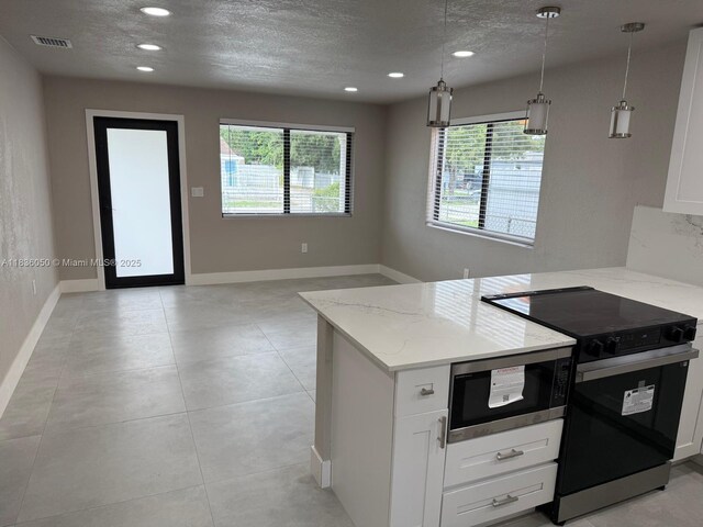 2441 NW 140th St, Opa Locka, FL 33054 - kitchen featuring black / electric stove, stainless steel microwave, light stone counters, a peninsula, and white cabinetry