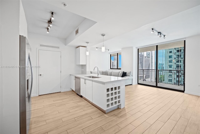999 SW 1st Ave Unit 1615, Miami, FL 33130 - kitchen featuring track lighting, appliances with stainless steel finishes, a peninsula, open floor plan, and floor to ceiling windows
