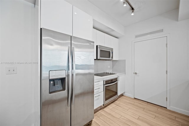999 SW 1st Ave Unit 1615, Miami, FL 33130 - kitchen with appliances with stainless steel finishes, light wood finished floors, white cabinetry, light countertops, and tasteful backsplash