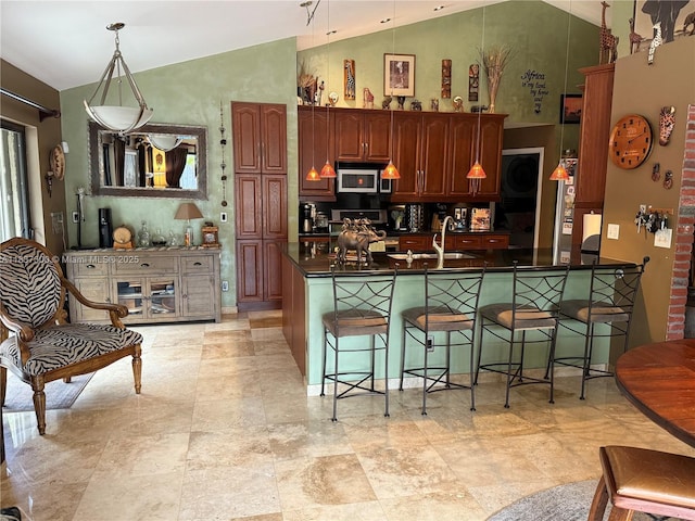 8878 SW 59th St, Cooper City, FL 33328 - kitchen with stainless steel appliances, dark countertops, a kitchen bar, high vaulted ceiling, and a peninsula