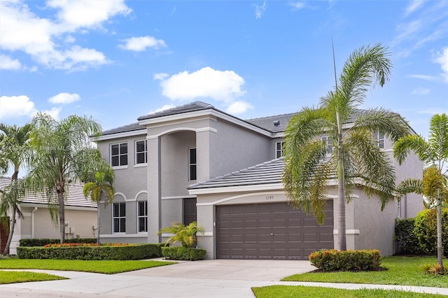 1249 Chenille Cir, Weston, FL 33327 - view of front facade featuring concrete driveway, an attached garage, stucco siding, and a tiled roof