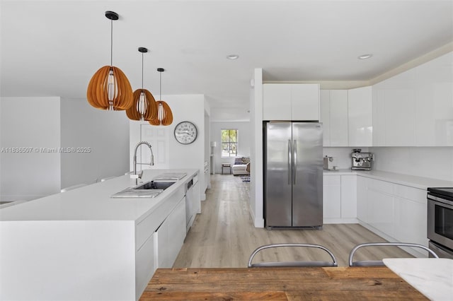 1249 Chenille Cir, Weston, FL 33327 - kitchen featuring appliances with stainless steel finishes, modern cabinets, light wood-style flooring, white cabinetry, and light countertops