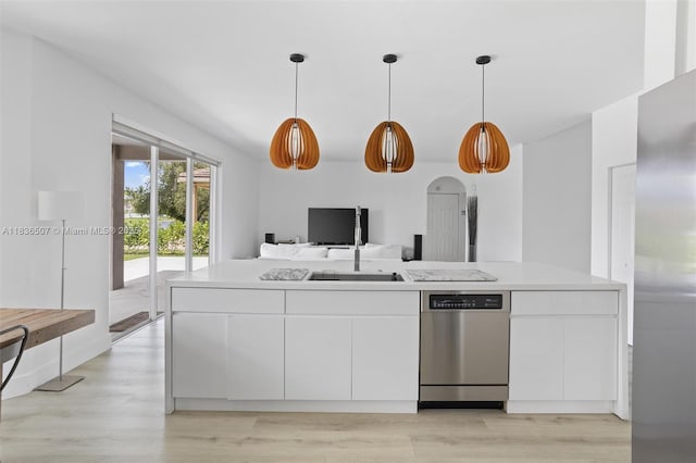 1249 Chenille Cir, Weston, FL 33327 - kitchen with stainless steel appliances, white cabinets, light countertops, light wood finished floors, and hanging light fixtures